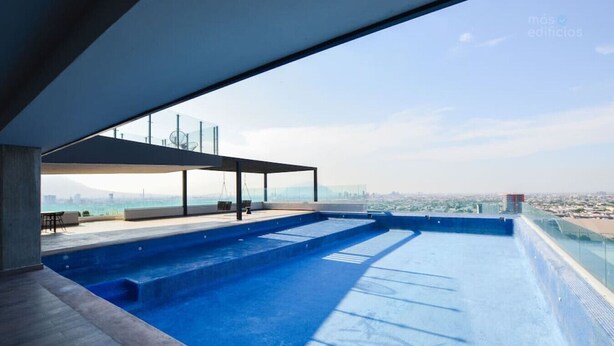 A rooftop infinity pool with a clear view of the city skyline.