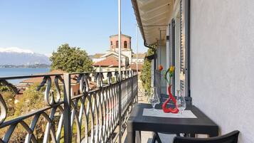 Un balcon agrémenté d’une table, de chaises et d’une sculpture en verre décorative.