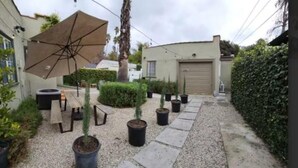 A courtyard with potted plants, a large umbrella, and a gravel pathway. - Amazing Studio in Pasadena! (Pasadena)