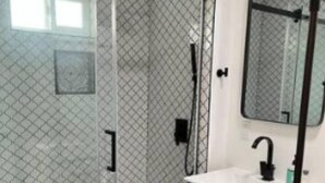 A modern bathroom with a glass shower enclosure, a white sink with a black faucet, and a mirror above the sink. - Amazing Studio in Pasadena! (Pasadena)