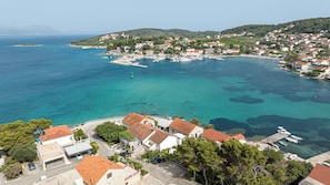 Eine Küstenstadt mit klarem türkisblauem Wasser, einer Marina und traditionellen Gebäuden mit roten Dächern.