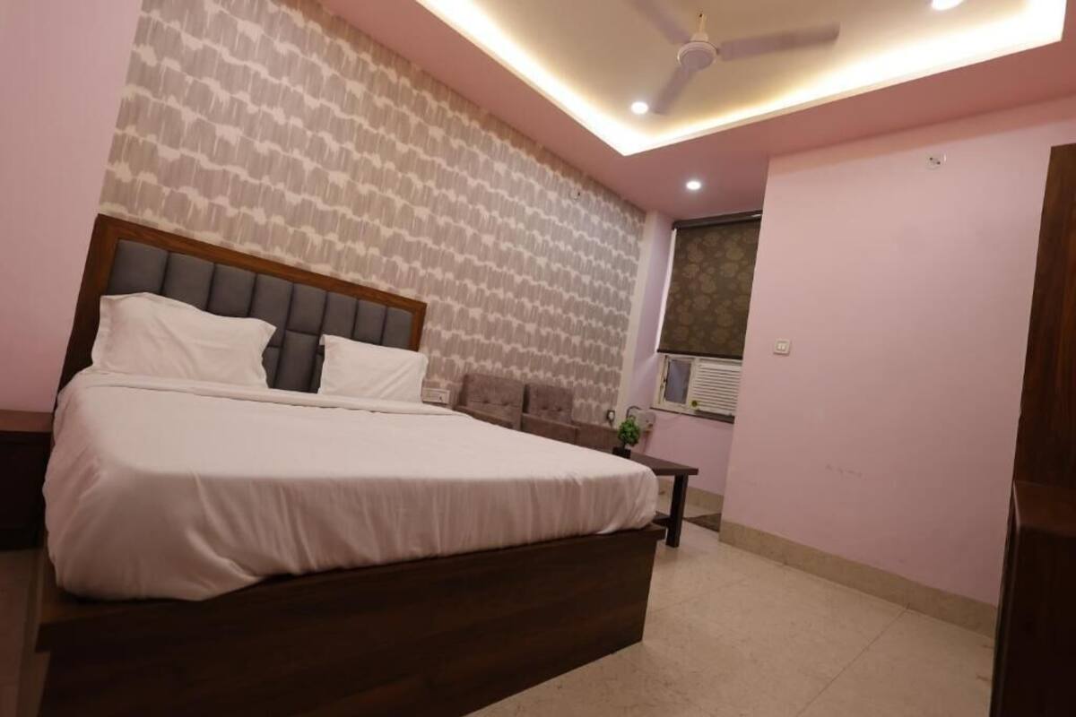 Un dormitorio con una cama grande, ventilador de techo y ventana con persianas.