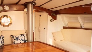 Un intérieur chaleureux avec une table en bois, un canapé confortable et une fenêtre ronde.
