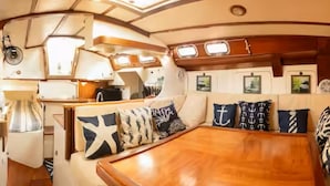 Un intérieur chaleureux avec une table à manger en bois, des sièges confortables et une décoration sur le thème de la marine.