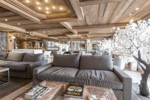 Ein gemütliches Wohnzimmer mit einer Eckcouch, einem Couchtisch mit Zeitschriften und einem großen Fenster mit Blick ins Innere.