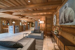 Eine geräumige Lobby mit Holzbalken, Steinsäulen und einem großen Gemälde eines Eisbären.
