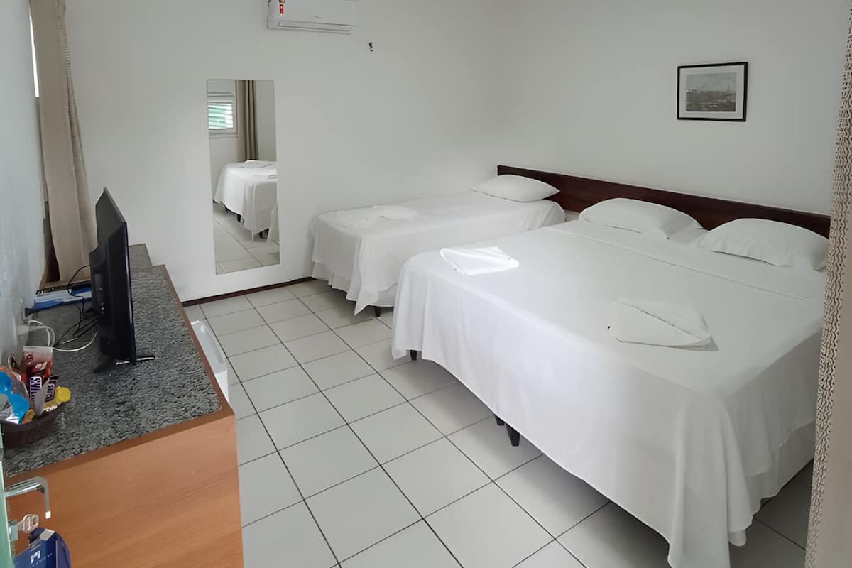 Ett hotellrum med två sängar, en TV och en luftkonditioneringsanläggning.