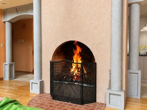Ein Kamin mit BacksteinfuĂ, umgeben von SĂ€ulen und einer schlichten Wand.