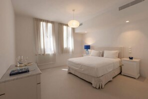 A modern bedroom with a large bed, a bedside table, a nightstand, a lamp, and a window with curtains. - Villa Caelia (Santa Maria)