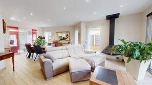 A modern living room with a sofa, dining area, and a fireplace.