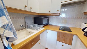 A compact kitchenette with a sink, a microwave, and a toaster. - Nautica - 1-Bedroom Apartment Near the Beach & Parking (Saint-Hilaire-de-Riez)