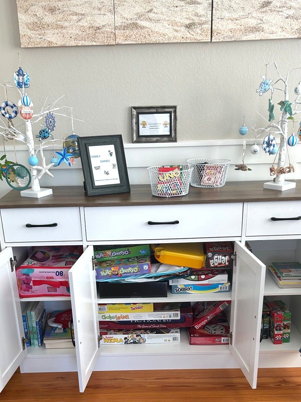 Ein Zimmer mit einem weißen Schreibtisch, Schubladen und Regalen voller Gesellschaftsspiele.