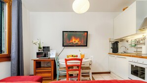A compact kitchen with a dining area, a TV mounted on the wall, and a window with curtains. - Venice Mestre Private Home - (Easy Access to Venice) (Venezia)