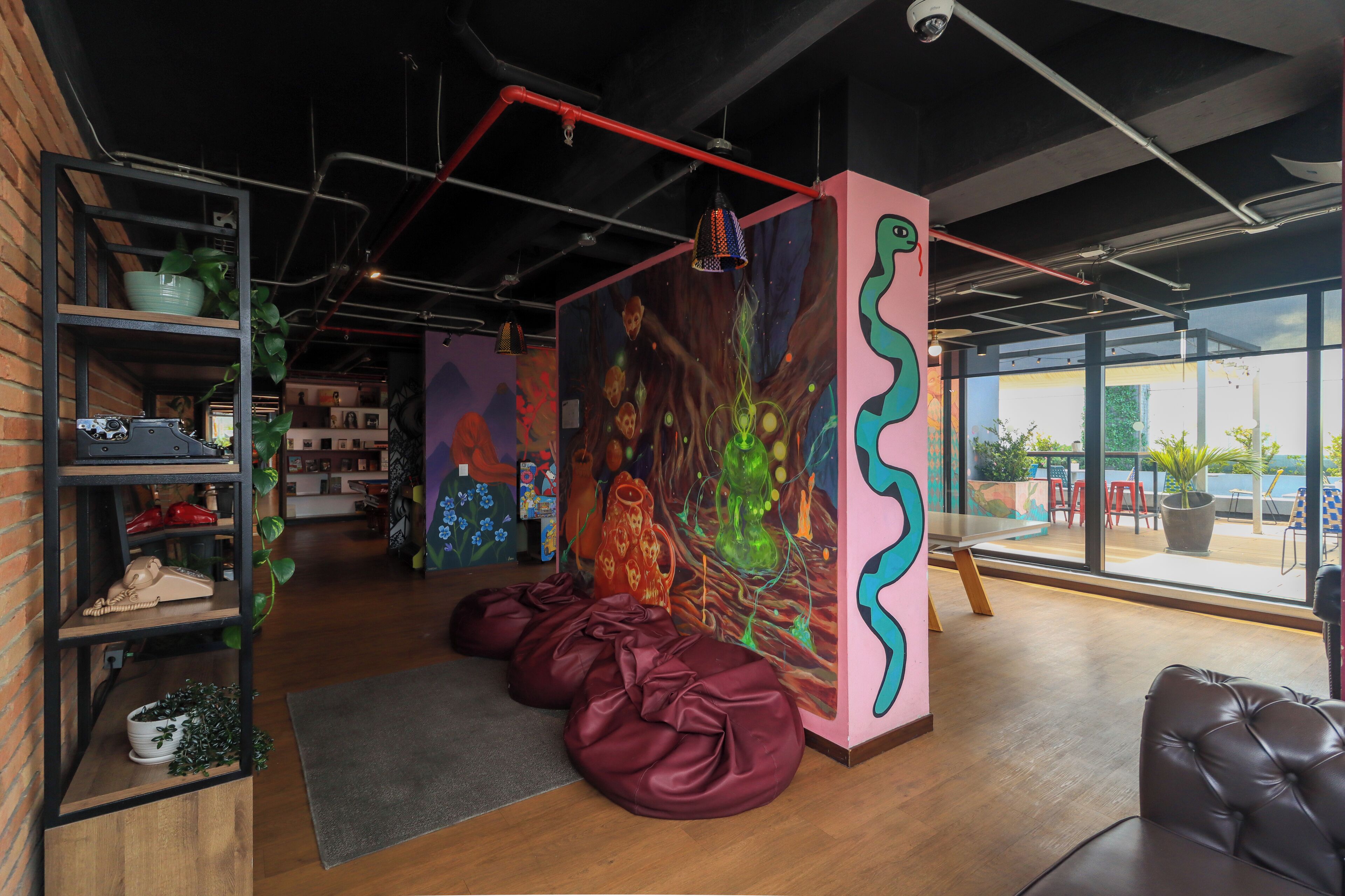 Un interior moderno con un gran cuadro abstracto, espacios de estar y vistas amplias a través de grandes ventanales.
