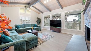 Amplia sala de estar con un sofá modular grande, un televisor de pantalla plana y una chimenea.