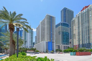 Un quartier urbain moderne, avec de hauts immeubles, des palmiers et un ciel dégagé.