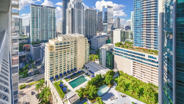 A high-rise hotel with multiple floors, a rooftop pool, and surrounding greenery. - Brickell Bay 3318 (Miami)