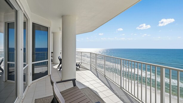 A balcony with a view of the ocean, a bench, and a table. - Beach & Gulf front Unit 1003 at Princess Condos 6415 Thomas Drive (Panama City Beach)