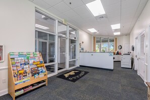 A reception area with a desk, a bulletin board with magazines, and a door marked 'EXIT'. - Princess Condos - All Units Are Gulf Front & Direct Beach Access in PCB! (Panama City Beach)