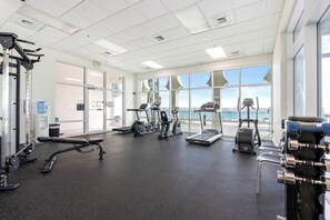 Ein Fitnessstudio mit Cardiogeräten, Gewichtstrainern und großen Fenstern mit Blick.