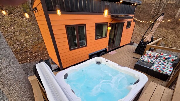A hot tub on a wooden deck with a small house in the background. - The Fox Den - Peaceful Tiny Home Retreat in the Mountains w/ Hot Tub & Fire Pit (Canton)
