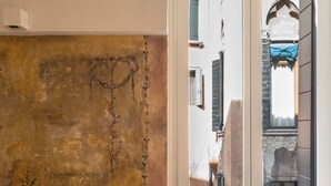 En smal gade med bygninger langs begge sider, en dør med hjerte-motiv og et vindue med blåt gardin.