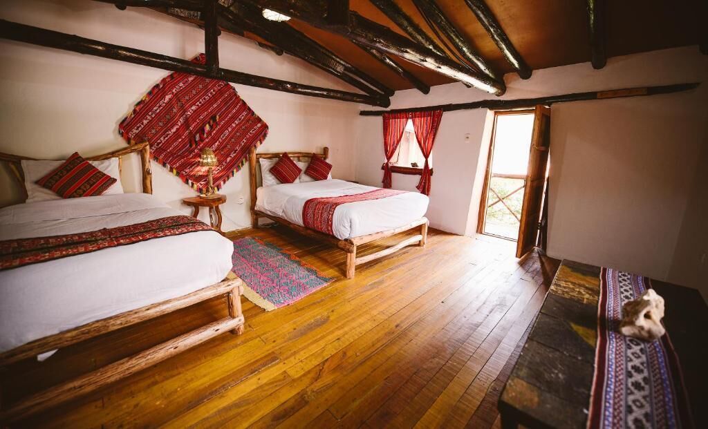 A traditional room with two wooden beds, a bench, and a small table.