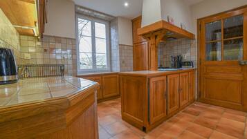 A kitchen with wooden cabinets, a tiled backsplash, and a window providing natural light.