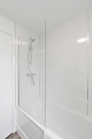 Een douche, een haardroger, handdoeken, shampoo