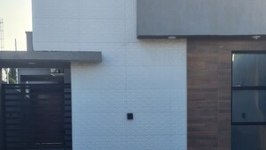 Ein modernes Gebäude mit Flachdach, einer großen Garagentür und einem kleinen Fenster.
