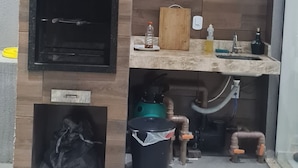 Ein modernes Badezimmer mit einer Holzwand, einem integrierten Waschbecken und einem schwarzen Fernseher an der Wand.