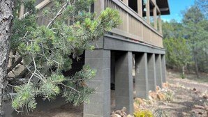 A two-story building with a balcony and a tree in front. - Wild Aspen Ridge | Space to Gather, Room to Unwind (Heber-Overgaard)