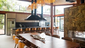 A modern kitchen with a stone wall, wooden ceiling, and hanging rattan lights. - Delta na Mata - Sto Amaro da Imperatriz (Santo Amaro da Imperatriz)