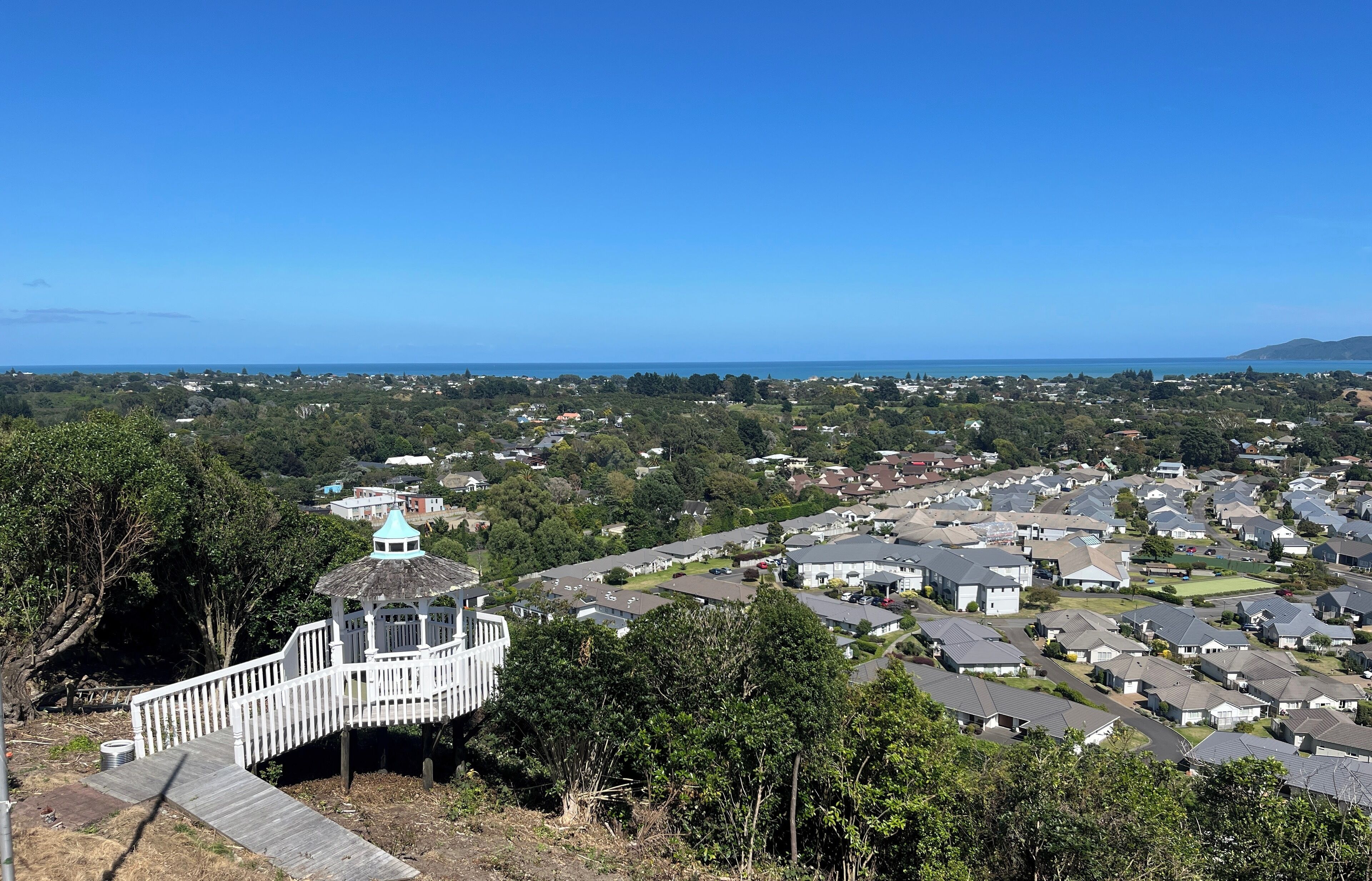 Um bairro residencial com uma estrutura semelhante a um coreto numa colina, com vista para a vizinhança.