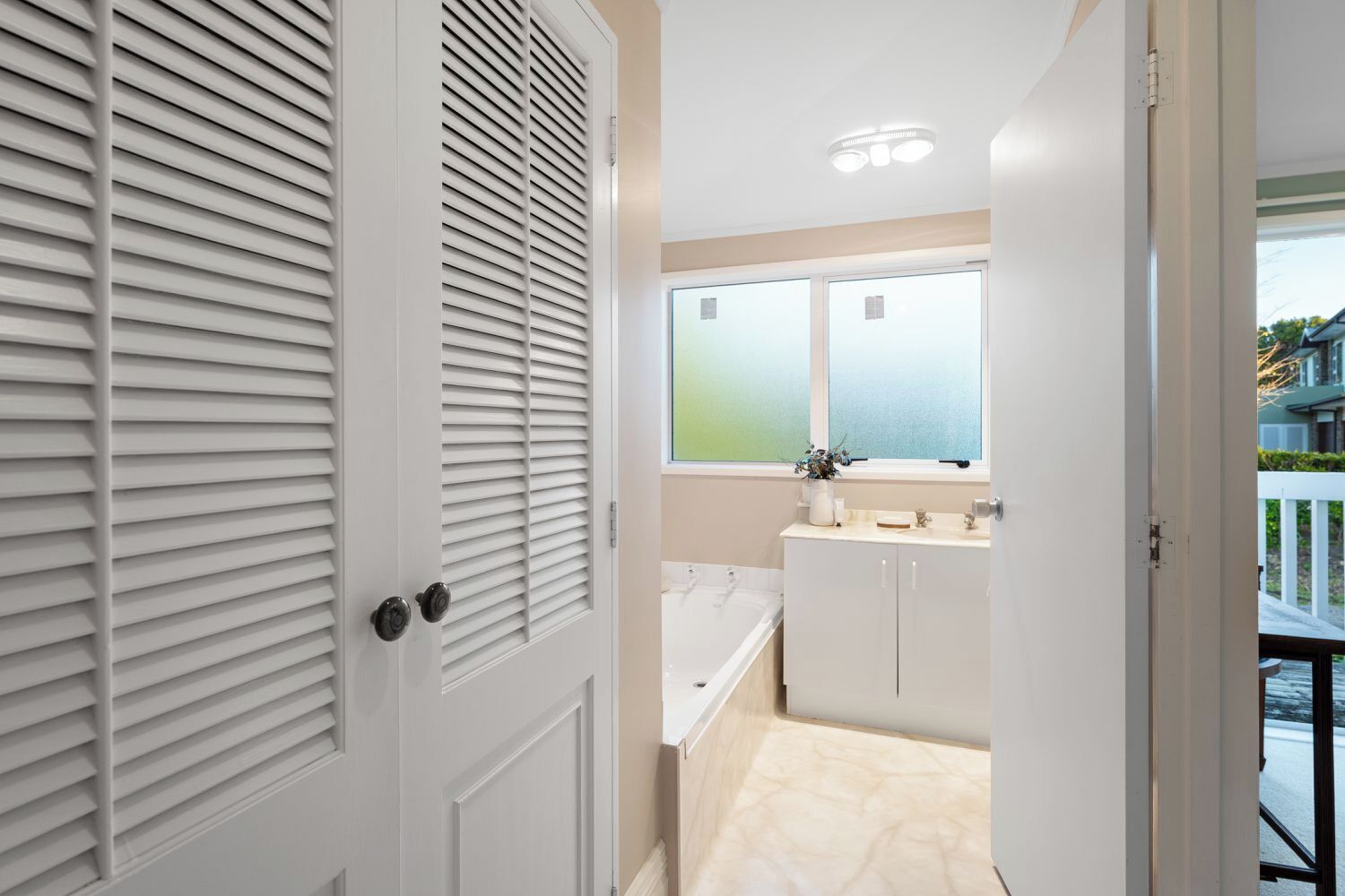 Une salle de bain moderne avec une baignoire, un lavabo et une fenêtre.