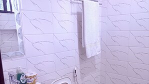 A bathroom with a toilet, sink, and a mirror.