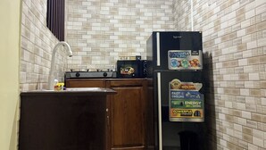A small kitchen with a refrigerator, microwave, and stove.