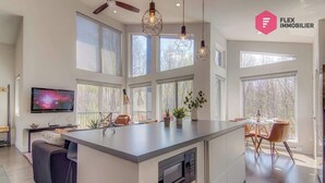 Una cocina amplia con una isla central, ventanas grandes y una zona de comedor.
