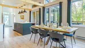 A modern kitchen with a dining area, large windows, and a view of the outdoors. - The Sunny-Haus in Portneuf - Private hot tub, Pool (Pont-Rouge)