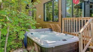 A wooden cabin with a hot tub, surrounded by trees. - The Sunny-Haus in Portneuf - Private hot tub, Pool (Pont-Rouge)