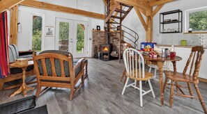 A cozy interior with a fireplace, wooden furniture, and a kitchen area.