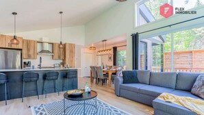 Een moderne keuken met een centraal eiland, barstoelen en hanglampen.