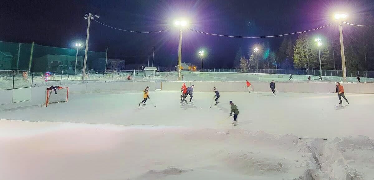 An outdoor ice skating rink at night with artificial lighting.