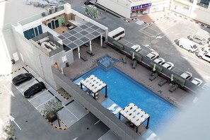 An aerial view of a hotel with a rooftop pool, outdoor seating, and a parking area. - Stayshort - Studio in Marina That Sleeps 3 With a Perfect City View (Dubai)