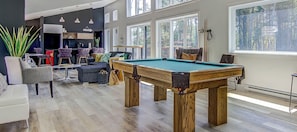 A pool table in a room with a bar area, seating, and large windows. - King bed, Cinema screen, Private SPA, Near Quebec (Pont-Rouge)