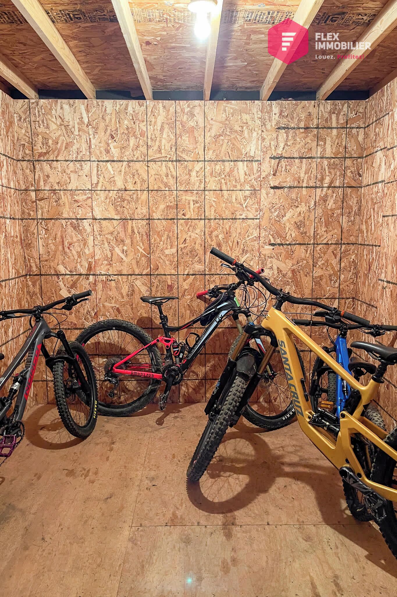 Una habitación con paredes de madera y techo inclinado, que contiene dos bicicletas.
