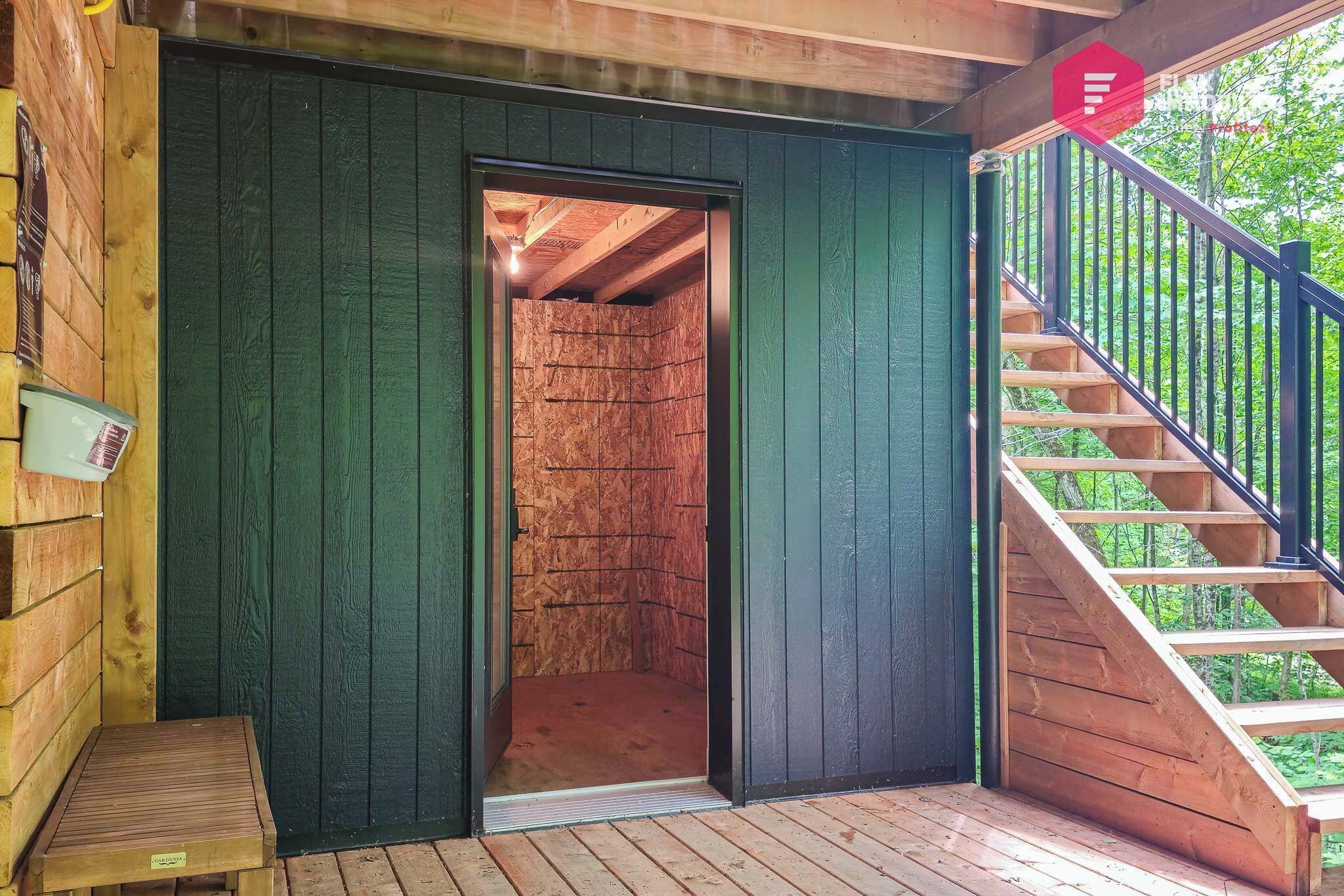 A wooden cabin with a staircase leading to an upper level.