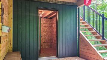 A wooden cabin with a staircase leading to an upper level.