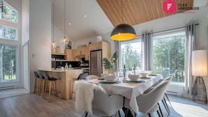Une cuisine moderne avec des meubles en bois, un îlot central et des luminaires suspendus.
