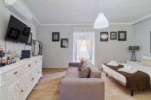 A modern bedroom with a bed, a sofa, a TV, and a desk with a lamp. - Lovely Fontenova A By Y Concept (Setúbal)